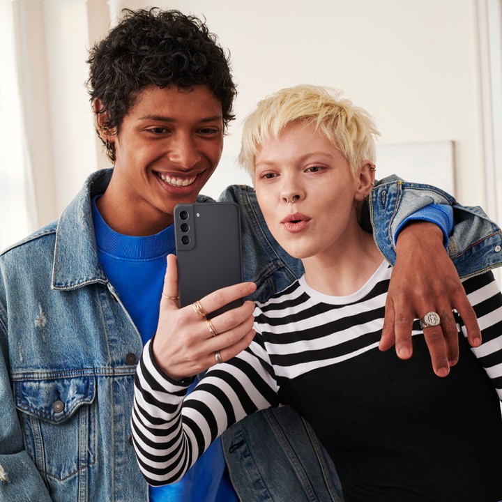 Um homem e uma mulher a tirar uma “selfie” com o Samsung Galaxy S21 FE 5G cinzento